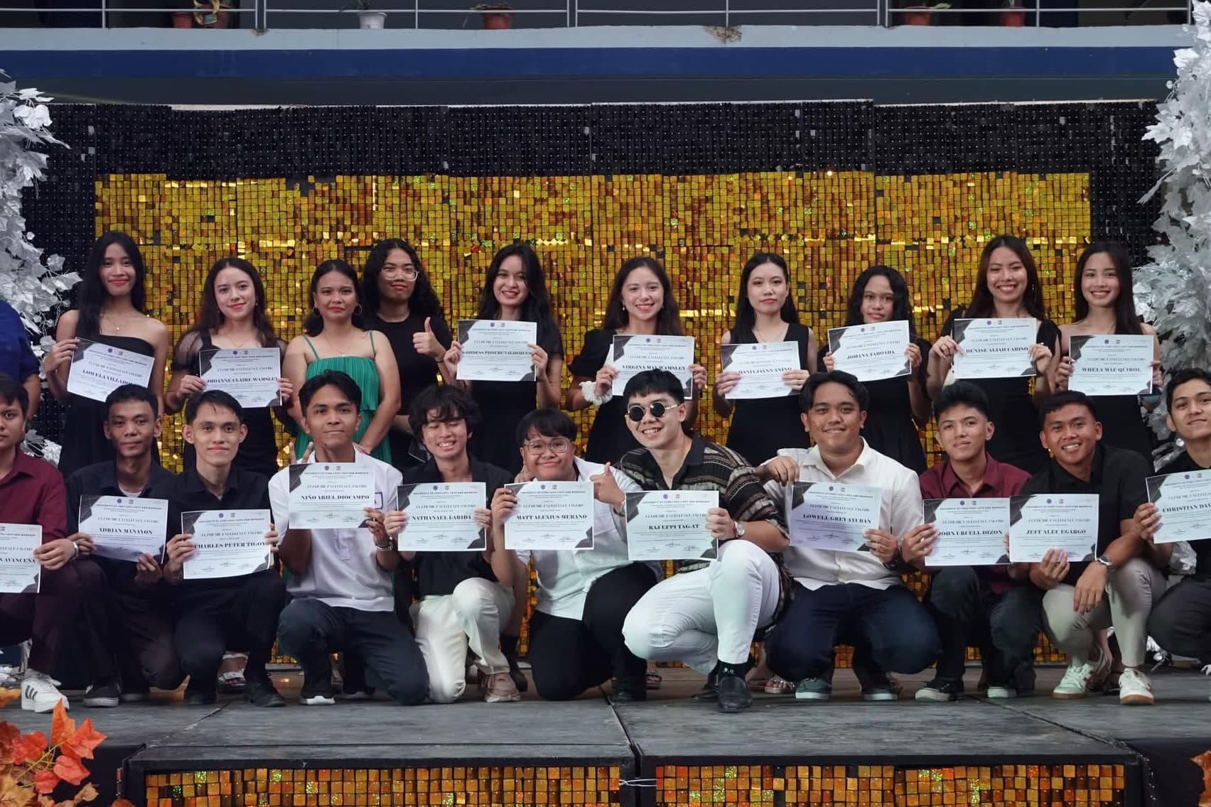 Dean's List awardees holding certificates during an academic recognition event